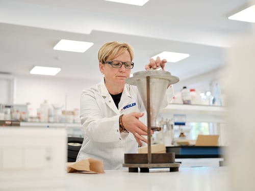 Colaborador de Weiler en un laboratorio midiendo granos abrasivos